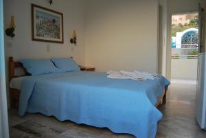 a bedroom with a blue bed with towels on it at Villa Anneta in Kamari