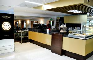 a woman standing at a counter in a restaurant at JetPark Auckland Airport Hotel in Auckland