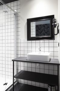 ein weißes Badezimmer mit einem Waschbecken und einem Spiegel in der Unterkunft Logis Hotel du Maine in Laval