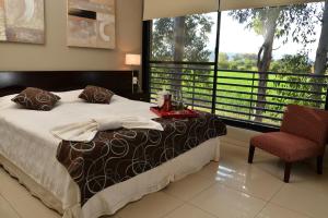 a bedroom with a bed and a chair and a window at La Wet in Tartagal