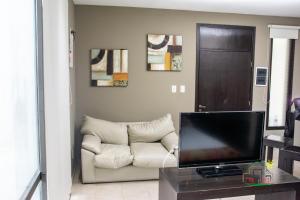 a living room with a couch and a television at La Wet in Tartagal