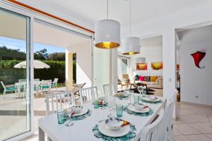 a white dining room with a white table and chairs at Villas Sol e Poesia in Albufeira