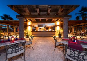 a patio with tables and chairs and a bar at Villa del Palmar at the Islands of Loreto in Loreto