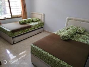 a room with two beds and a chair and a table at Rumah Retret Bethania in Kuta