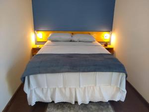 a bedroom with a large bed with two night stands at Pousada Container Eco Manguinhos in Manguinhos