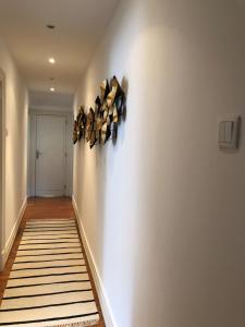 a hallway with a white wall with a shelf on it at Botanic Views Guest House in Lisbon