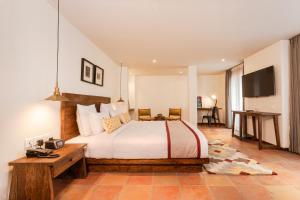 ein Schlafzimmer mit einem großen Bett und einem TV in der Unterkunft Hotel Roadhouse in Kathmandu