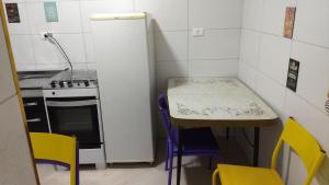 a small kitchen with a table and yellow chairs at Yellowkits in São Paulo