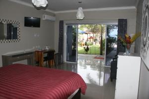a bedroom with a red bed and a sliding glass door at Silver Fern Beach Retreat in Sekotong