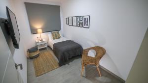 a small bedroom with a bed and a chair at Brazan Holidays in Corralejo