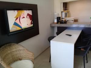 una cucina con frigorifero bianco e TV a parete di Flat Marinas - Cabo Branco - João Pessoa a João Pessoa Altre 14 foto