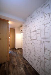 a room with a white brick wall and wooden floors at Trip & Sleep Hostel in Nagoya