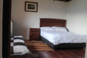 a bedroom with a bed and a dresser and a bed sidx sidx sidx sidx at Chalet Guatavita - Tominé. La Casa Amarilla in Guatavita