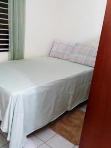 uma pequena cama num quarto com uma colcha branca em Cozy & Comfy em Portmore