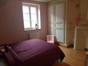 ein Schlafzimmer mit einem lila Bett und einem Fenster in der Unterkunft Logis la Rotourelle in Torcy-le-Grand