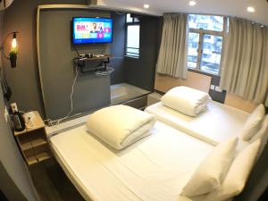 a hospital room with two beds and a tv at Soso Hostel in Hong Kong