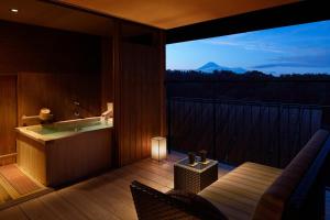 a room with a bath tub on a balcony at Laforet Shuzenji Sanshisuimei in Izu