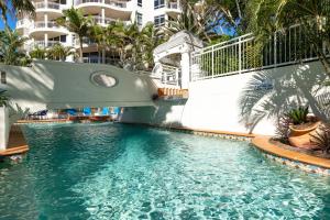 a large swimming pool with a boat in the water at Burleigh Mediterranean Resort in Gold Coast