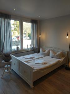 グリュックスブルクにあるApartment Strandkorbのベッドルーム(大きな白いベッド1台、窓付)