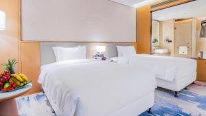 Voodi või voodid majutusasutuse Wyndham Grand Plaza Royale Yuzhou Xiamen Wuyuan Bay toas