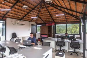 two men working in an office with tables and chairs at Moustache Goa Cowork Hostel in Mandrem