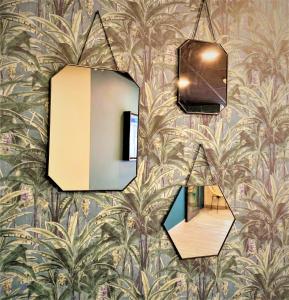 a mirror hanging on a wall with a wallpaper at Hôtel Boutique Richelieu, Lyon Gare Part-Dieu in Lyon