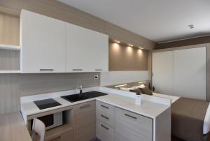 a kitchen with white cabinets and a sink at Residence all'Adige in Verona