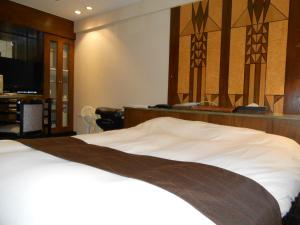 um quarto com uma cama, uma escrivaninha e uma TV em Hotel Lumiere Gotenba (Adult Only) em Gotemba