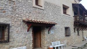 a stone building with a wooden door and a bench at Casa Rural Mirabueno in Cuenca