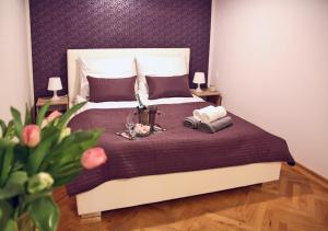 1 dormitorio con 1 cama con pared morada en Marilyn Apartment, en Łódź
