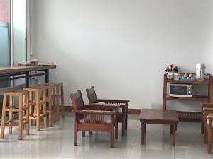 a room with wooden chairs and a table and a microwave at UD Residence in Udon Thani