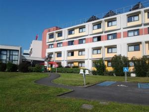 un bâtiment avec une route courbe devant lui dans l'établissement ibis Bordeaux Lac, à Bordeaux