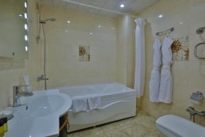 a bathroom with a tub and a sink and a toilet at Ganjali Plaza Hotel in Baku