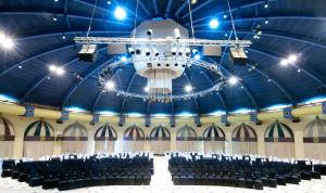 a chandelier hangs from the ceiling of a large auditorium at Herods Palace Hotels & Spa Eilat a Premium collection by Fattal Hotels in Eilat +37 photos