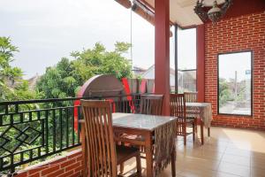 a patio with a table and chairs on a balcony at OYO 465 Alam Citra Bed & Breakfast in Yogyakarta