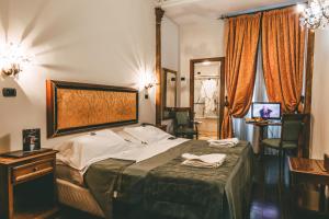 a hotel room with a bed and a table and chairs at Domus Florentiae Hotel in Florence