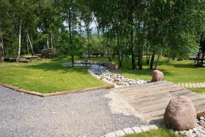 a garden with a wooden bridge and a pond at Świetnokrzyska Chata in Bodzentyn