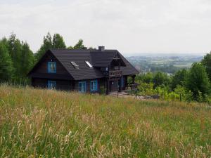 a house sitting on top of a hill with a field at Świetnokrzyska Chata in Bodzentyn