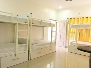 a room with three bunk beds and a table at Moustache Goa Cowork Hostel in Mandrem