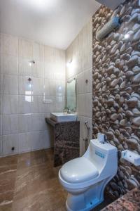 a bathroom with a toilet and a sink at Moustache Goa Cowork Hostel in Mandrem