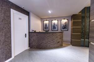 a lobby with a stone bar with three pictures on the wall at Parallel Hotel in Baku