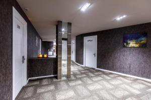 a hallway with two white doors and a wall at Parallel Hotel in Baku