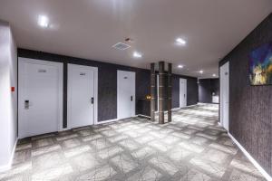 a hallway with four doors and a tile floor at Parallel Hotel in Baku