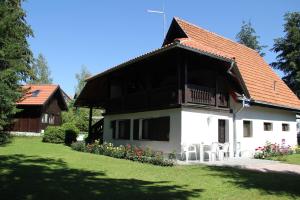 Casa blanca con techo marrón y patio en Apartmani U Borovoj Šumi, en Zlatibor