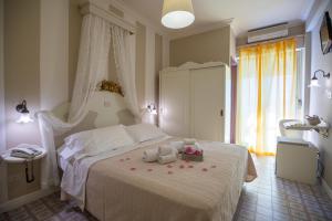 a bedroom with a white bed with flowers on it at Hotel Mocambo piscina e spiaggia in San Benedetto del Tronto