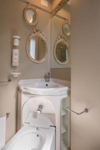 um banheiro com uma pia e dois espelhos em Hotel Mocambo piscina e spiaggia em San Benedetto del Tronto