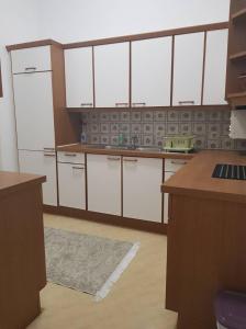 a large kitchen with white cabinets and a rug at Ferienwohnung Schloessel 26/16 in Vienna