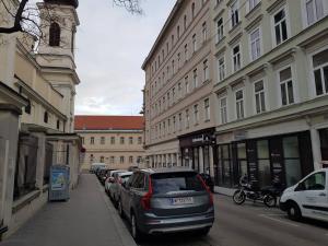 una calle de la ciudad con coches aparcados en la acera en Ferienwohnung Schloessel 26/16, en Viena
