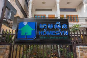 a sign in front of a building with a house at Homesyn Hotel in Phnom Penh