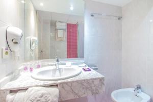 
a bathroom with a sink, mirror and bath tub at Hotel Servigroup Torre Dorada in Benidorm
